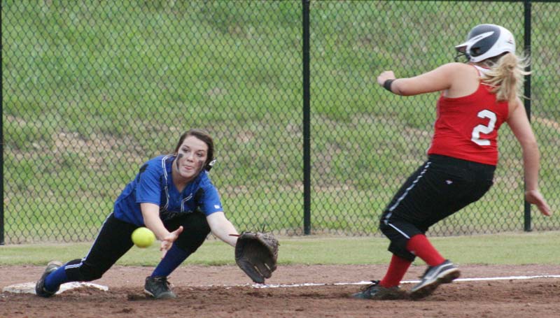DAILY LEADER / MARTY ALBRIGHT / Brookhaven Academy shortstop K.K. Jordan stretches to make the play at third base before Trinity's runner Kaitlyn Lees could reach the bag during the Thursday night in softball action at Brookhaven Academy.