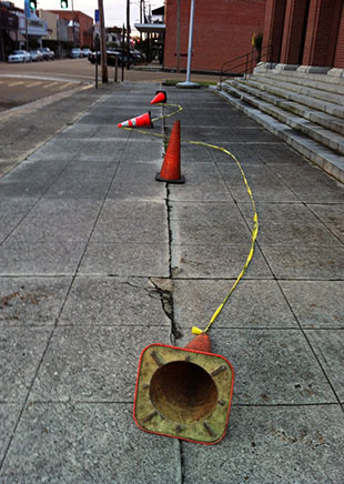 DAILY LEADER / Cones and caution tape have been placed along the sidewalk in front of the downtown Post Office.
