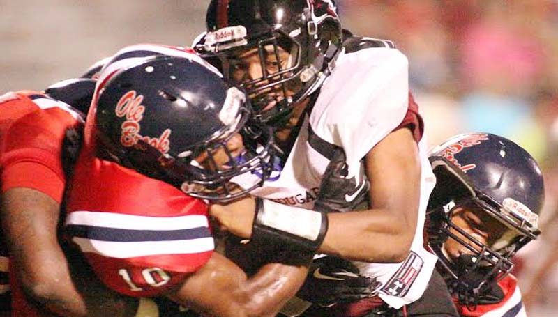 DAILY LEADER / JONATHON ALFORD / Brookhaven defensive tackles Leo Lewis (40), Montero Barton (10) and Ben Robinson (8) smother Lawrence County running back T-Tex Cole in Friday night action at King Field.