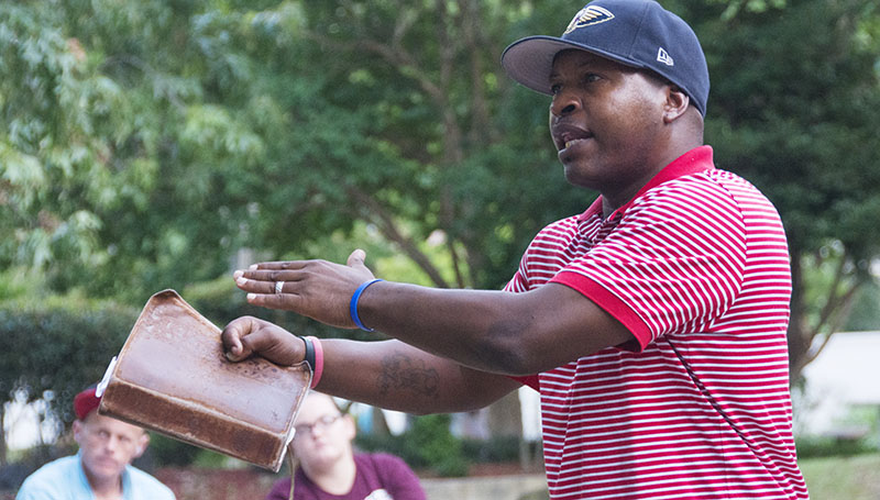 DAILY LEADER / KATIE WILLIAMSON / Pastor Troy Gause, with Church Without Walls in New Orleans preaches at City Park to a group of the homeless in downtown Jackson last Saturday, Aug. 23. He tells the story of David and how everyone, like David, can be chosen by God to become a queen or king, even if society has cast them aside.