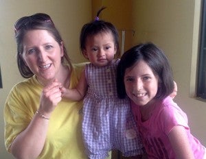 Stephanie Freeman (left) and her daughter Abi (right) hold Baby Naomi, one of the Casa de Fe children. Naomi came to the orphanage with a colostomy bag and later had surgery to repair her intestines. She was fostered by the Freemans during her six-month recovery period. 
