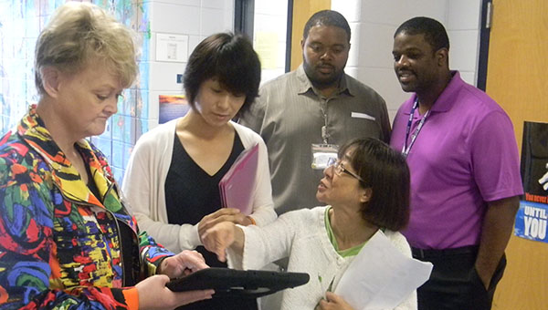 PHOTO SUBMITTED / Donna Horton, director of client services at Mississippi Adolescent Center in Brookhaven, demonstrates a program called Talking Tiles with Yukari Ogita, member of the Osaka Prefectural Assembly, Health and Welfare Committee, of Japan, and her translator during a recent visit to the local facility. Looking on are Eric Brown, director of staff development at MAC, and Bobby Alsworth, principal of MAC.