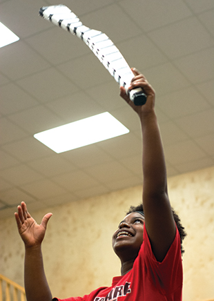 DAILY LEADER / KATIE WILLIAMSON / Lanora Lundy, 17, throws a wooden rifle in the air during the practice session.