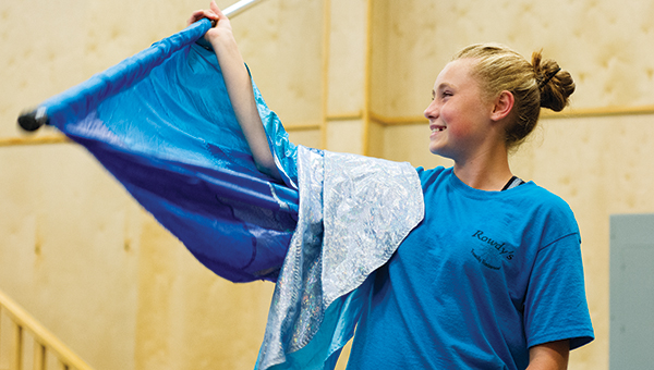 DAILY LEADER / KATIE WILLIAMSON / Natalie Lynn, 13, laughs as she practices flag twirling during Loyd Star color guard practice.