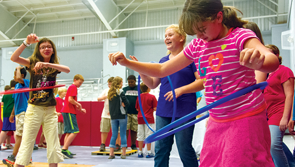 DAILY LEADER / KATIE WILLIAMSON / The Brookhaven Junior Auxiliary hosted a health fair at Enterprise School Wednesday to teach children about the importance of a healthy diet, daily exercise and good hygiene. Chloe McCormick, 13, (from left) Molly Thompson, 11, and Jacy Jordan, 12, hula hoop during the exercise portion of the health fair.