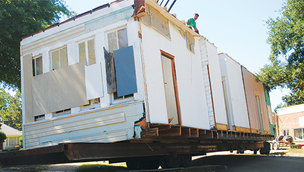 DAILY LEADER / JULIA V. PENDLEY / Jeffery Strickland, of Van Norman House Movers, helps maneuver part of a house around power lines from the top of the structure. The house sat on Brookhaven First Assembly property.