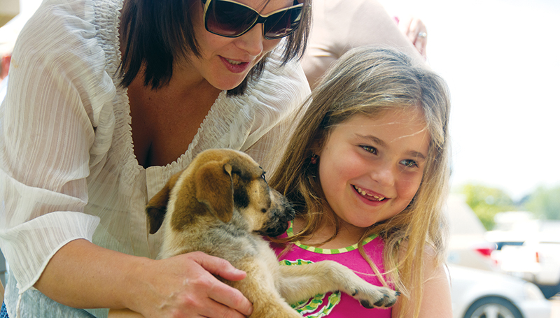 DAILY LEADER / KATIE WILLIAMSON / April Case helps her daughter Emma Case, 6, hold a puppy at the BARL/Copiah Animal Shelter adoption event at Pet Sense Sunday.