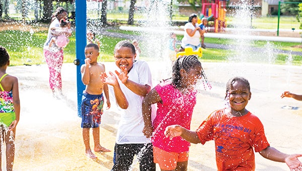 Photo by Kaitlin Mullins Tykerrious Hilliard says “cheese” during a friends and family gathering at Bicentennial Park recently. The spray parks around Brookhaven are a very popular place for kids to expel extra energy while enjoying the weather outside.