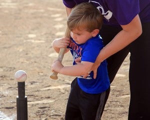 Organizer Kail Garrett helps a player get ready to swing. 