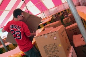 Adam Whittington unloads boxes filled with fireworks while setting up Hood’s fireworks stand on Hwy 84.