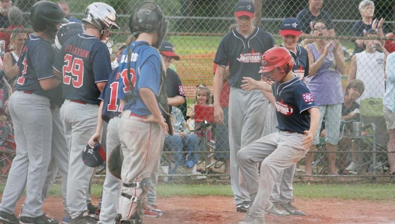 DAILY LEADER / MARTY ALBRIGHT / Lincoln County Nationals' Colby Carwyle is greeted at home plate by his teammates after hitting a two-run home run in the fourth inning against Walthall County Thursday night in Bude.