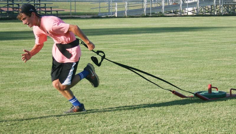 DAILY LEADER / Jacob Cartwright works on his speed while pulling a weighted sled during Bogue Chitto's summer workout.