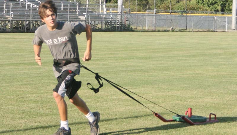 DAILY LEADER / Steven Allen sprints down the field while pulling a weighted sled during Bogue Chitto's summer workout.