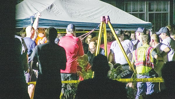 Photos by Kaitlin Mullins and Julia V. Pendley Rescue crews cheer as the boy is pulled from the hole Monday evening.