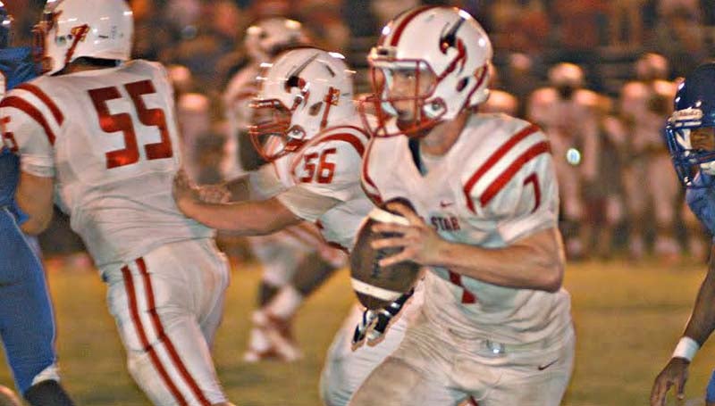Chris Allen Baker / Scott Times / Loyd Star's quarterback Parker Flowers (7) looks down the field as teammates Nicholas Smith (55) and Tucker Watts (56) provide coverage Friday night. The Hornets were defeated by Scott Central 33-18. Complete coverage of the game will be published in Tuesday's edition.