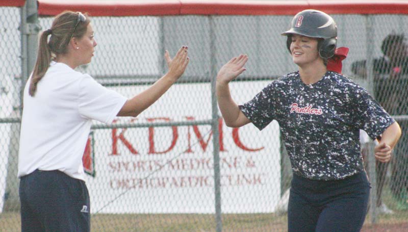 Daily Leader / Marty Albright / Brookhaven's Katherine Shell receives an congratulation high-five from her coach Mandy Vinson (left) at third base after hitting a pair of two-run home runs Tuesday against Murrah.
