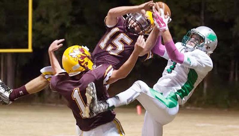 Daily Leader / Teresa Allred / West Lincoln's Chase Owens (7) leaps into the air for a catch Friday night while being double team by Enterprise's Zach Hodges (15) and Trestin Cantrell (1).