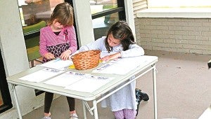 Photo by Kaitlin Mullins From left, Amory and Sadie Walker color notes to troops during a candy buy-back Monday at Ole Brook Pediatric Dentistry. The dental office through Operation Gratitude is sending candy and hand-written notes to service members.