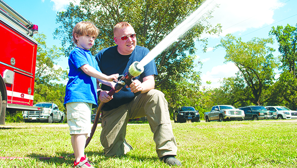Photo by Julia Miller / Gabe Albritton, left, fell in a well on Labor Day. Fortunately, he was rescued unharmed. Zetus Volunteer Fire Department returned to reward Gabe with pizza and ride in the fire truck.