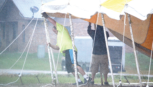 Photo by Luke Horton/ Two men work in the rain to erect a large fireworks tent on Dunn-Ratcliff Road Tuesday morning. Wet weather is expected to continue through Wednesday morning. See page 3 for a two-day forecast.