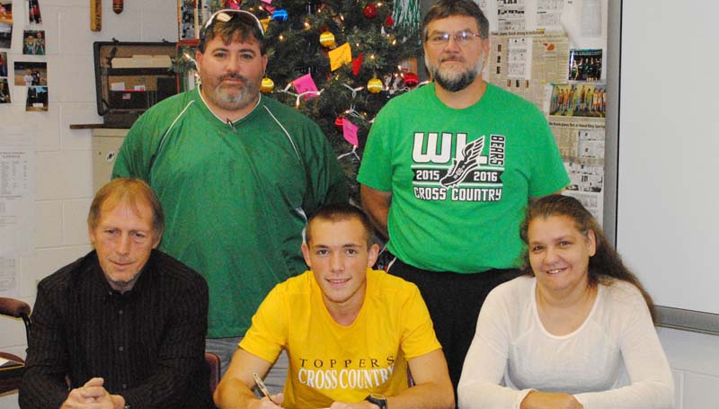 Daily Leader / MARTY ALBRIGHT / West Lincoln's Jason Watts signs a cross-country scholarship with the Blue Mountain College Toppers. Pictured with Jason is his father Gary Watts (left) and his mother Angie Watts (right); (standing from left) West Lincoln Athletic Director Charlie Jackson and Head Cross-Country Coach Greg Allen.