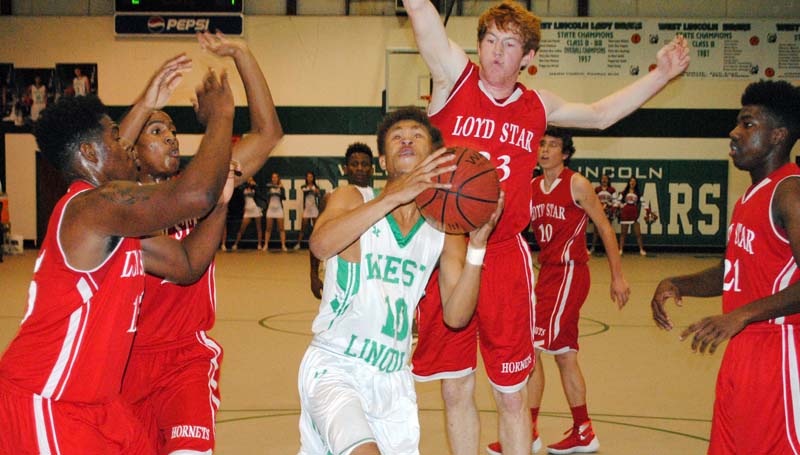 Daily Leader / Marty Albright / West Lincoln's senior Ronnie Edwards drives to the basket between several Loyd Star defenders Avery Leggett (15), Javion Beard (2), Levi Redd (23) and Patrick Price (21) Thursday night.
