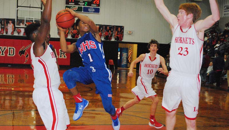 Daily Leader / Marty Albright / Wesson's Shemar Dickerson (1) takes a tough acrobatic shot between two Loyd Star defenders Avery Leggett (15) and Levi Redd (23) Tuesday night.