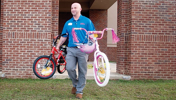 Photos by Julia Miller / Above, James Case of Toyota of Brookhaven helps carry bikes to people's vehicles during Wish Tree distribution. Over 200 children were served with this year's community effort led by Junior Auxiliary.
