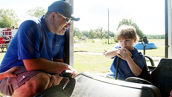 Photo by Julia Miller / Chris Reed talks to Gabe Albritton a few days after the boy was rescued from a well on Labor Day. Reed gives back to his community through his volunteer service with the Hog Chain Volunteer Fire Department.