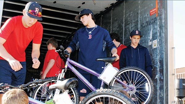 Photo by Aaron Paden/ The Brookhaven High School baseball team, overseen by coach Randy Spring, loads a truck with 285 bicycles Monday at the Wal-Mart distribution center. The bicycles are being given to Junior Auxiliary’s annual Wish Tree project by an anonymous donor.