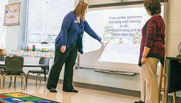 Photo by Kaitlin Mullins / Dean Jackie Martin (left) and preschool teacher Melissa Kyzar check out the educational games that children at the Copiah-Lincoln Early Childhood Education facility enjoy playing on the new smart board. The new facility was finished in November.