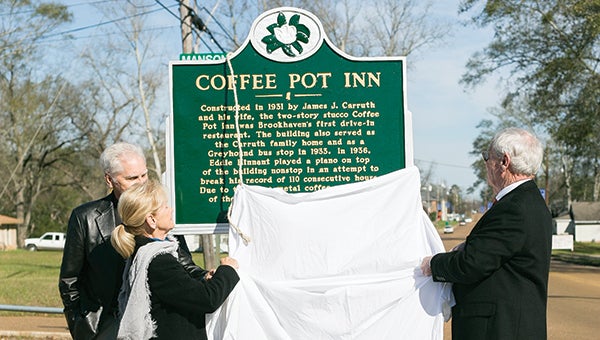Photo by Kaitlin Mullins From left, Paul Ott, Lu Becker and Ed Carruth unveil the historical marker for the Coffee Pot Inn on Wednesday. Becker and Carruth are the grandchildren of the Carruths who founded the inn and restaurant, and Ott is their cousin. 