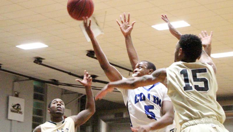 Co-Lin Media / Natalie Davis / Co-Lin point guard Jonathan Dalton (12) splits the East Central defense of Keion Peoples (11) and Prince McDaniel (15) Thursday night.