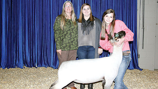 Photo by Alex Jacks / Supreme champion market lamb, Rachel McDaniel and her buyers pose after the Sale of Champions Monday night.