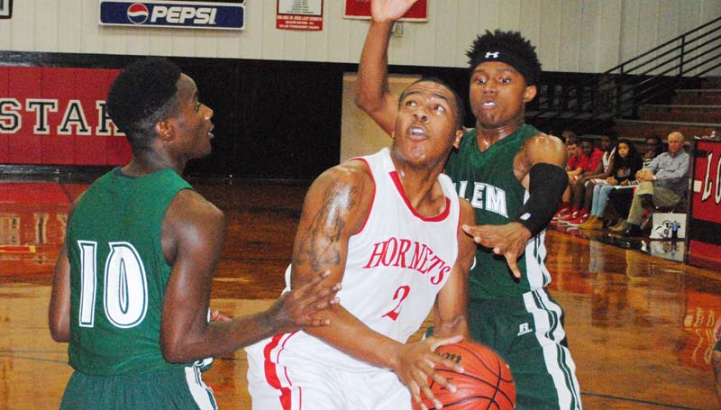 Daily Leader / Marty Albright / Loyd Star's Javion Beard (2) battles in the paint against two Salem defenders in Monday night boys' action at Loyd Star Gymnasium.