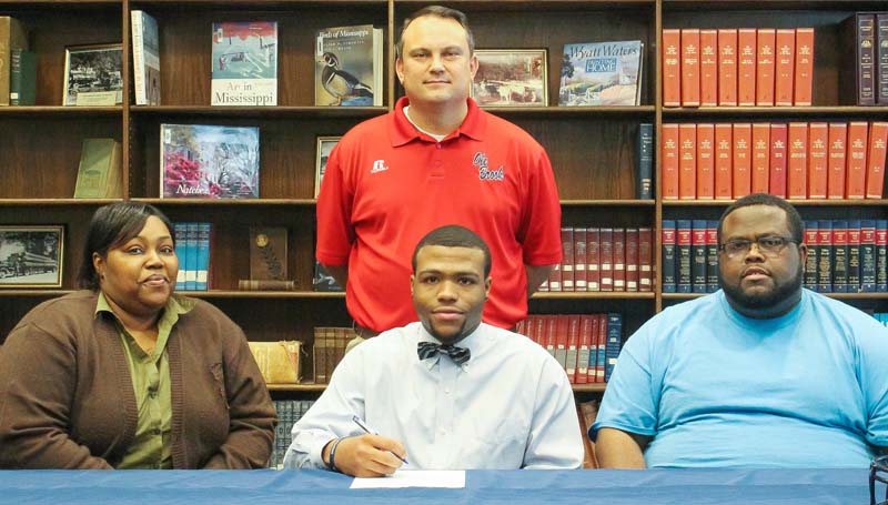 Daily Leader / April Clopton / Brookhaven's Dedric Smith has signed a football scholarship with the Gulf Coast Community College Bulldogs. Pictured with Smith are his parents Debra and Dedric Smith Sr. Standing is Brookhaven's head football coach and athletic director Tommy Clopton.