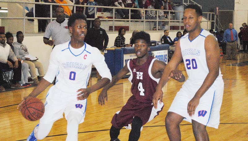 Daily Leader / Marty Albright / Wesson's Anthony Jones (0) drives to the basket as teammate Kendrick Brown (20) sets a block against Hazlehurst's ZyQuaris Watkins (4) Thursday night at the Snake Pit.