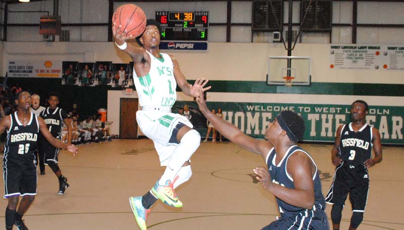 Daily Leader / Marty Albright / West Lincoln's Keshaun London (11) makes a acrobatic layup over Bassfield's Racheem Booth (10) Thursday night in boys tournament action.