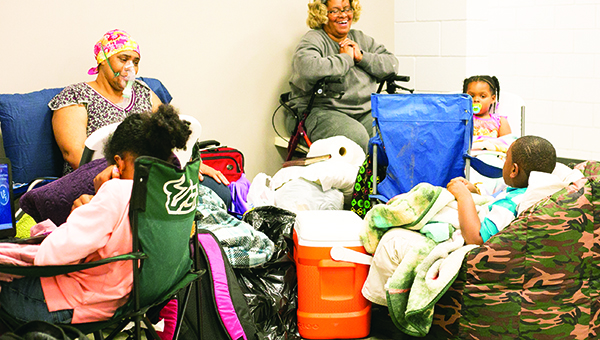Photo by Kaitlin Mullins / Leticia Coleman (left) and Ann Moore (right) gathered with relatives in anticipation of Tuesday’s weather at the FEMA building. Coleman and Moore, both of whom live on Industrial Park Road, said they weren’t taking any chances, especially losing power. About a dozen people took shelter there.