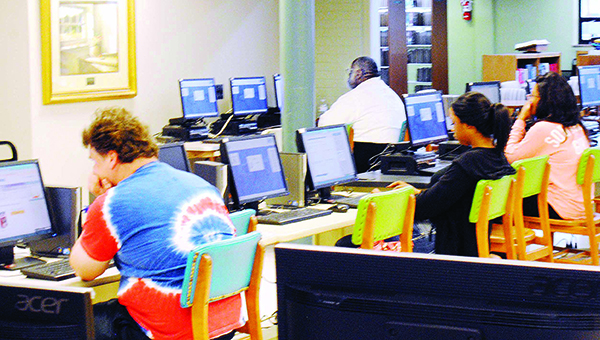 Photo by Aaron Paden / Local residents make use of the Lincoln County Public Library computers Friday. People come who don’t have Internet access themselves or who just want to take advantage of the quiet atmosphere.