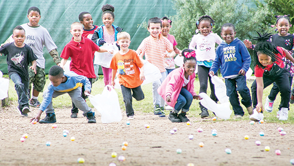 Photos by Kaitlin Mullins / Kindergartners at Mamie Martin Elementary descended in droves upon the egg-littered playground Wednesday afternoon. children explode off of the fence at the signal — a wave of Principal Rob McCreary’s hat. The 5-year-olds collected all of the eggs in less than 30 seconds.