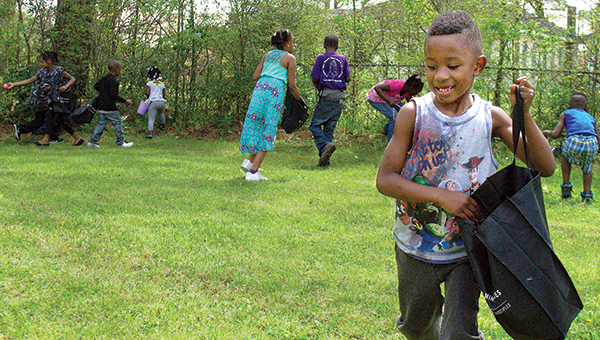Photo by Aaron Paden / DJ Smith races for Easter eggs at the Kynett United Methodist Church Saturday. The church also served hotdogs and hosted local hip-hop group #TEAMBROKE at the event.
