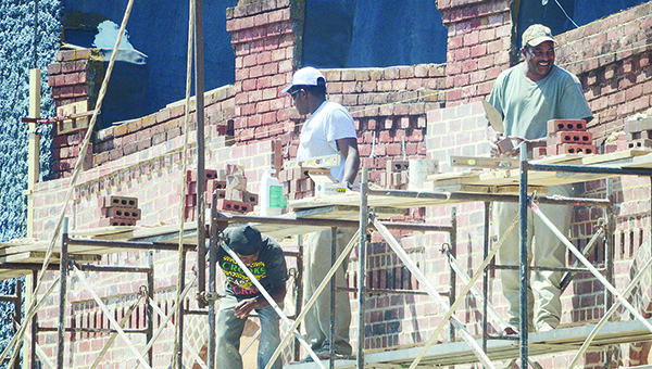 Photo by Luke Horton / Bricklayers work to restore the outside of a downtown building. This is just one of the many renovations that entrepreneurs are funding in Brookhaven.