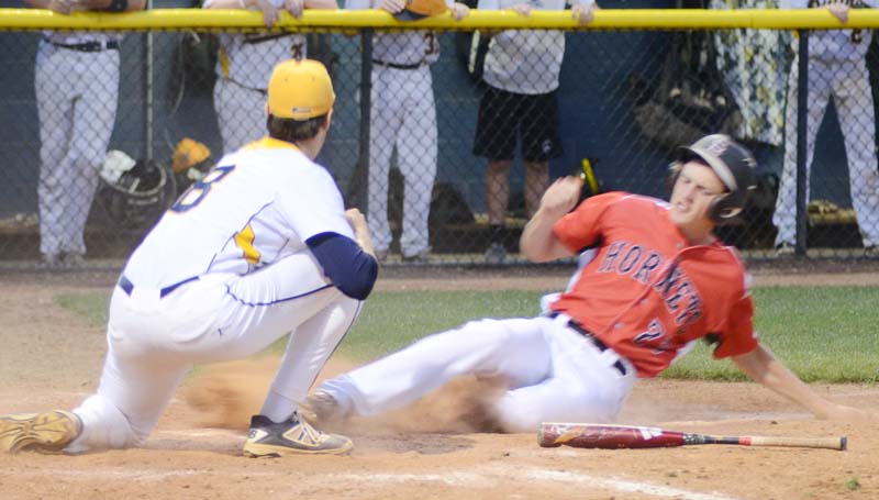 Daily Leader / Marty Albright / Loyd Star's Dane Smith (23) slides safely under the tag of Madison St. Joe's pitcher Jack Garrard (8) to give his Hornets a 6-5 lead in the top of the seventh inning.