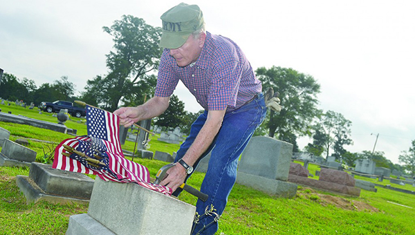 Photo by Donna Campbell/ American Legion Post Commander Keith Reeves and other volunteers gathered at Rose Hill Cemetery Saturday morning to place flags in front of the graves of fallen soldiers for Memorial Day.