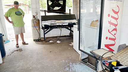 Photo by Donna Campbell/Exchange Club President Roger Leggett looks over damage to one of the coolers under a food pavilion at the Exchange Club Park fairgrounds Friday.