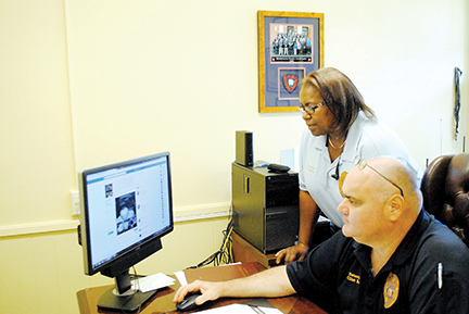 Photo by Aaron Paden/Capt. Clint Earls and Sgt. Penelope Banks go through the department’s Facebook page Wednesday as part of their daily schedule in a new effort to connect to the community through social media.