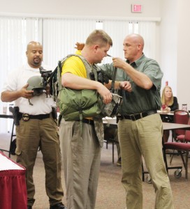 Photo by Alex Jacks/Deputy Jason Gaskin and investigator Damian Gatlin help Rayborn into the bulletproof vest an officer would wear while tracking down an active shooter.