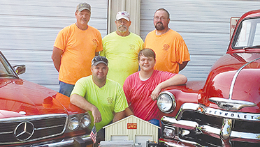 Submitted photo/Volunteers at the New Sight Fire Department are ready for the annual “Smoking Tires and Putting Out Fires” car show and festival Saturday. Showing off a handcarved replica of their new pumper is President Don Smith (back row, left), firefighter Roger Hill, Vice President Warren Allen; Chief Cory Smith (front row) and car show chairman Austin Smith. Funds from the festival will help pay for the pumper the VFD purchased in March.