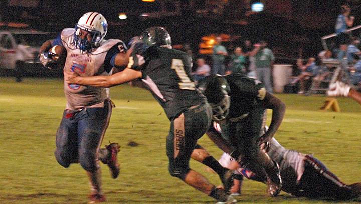 Photo by Tracy Fischer/ Junior Cobra fullback Jerry Barlow stiff arms McLaurin defender Austin Sandifer as he fights for extra yardage.